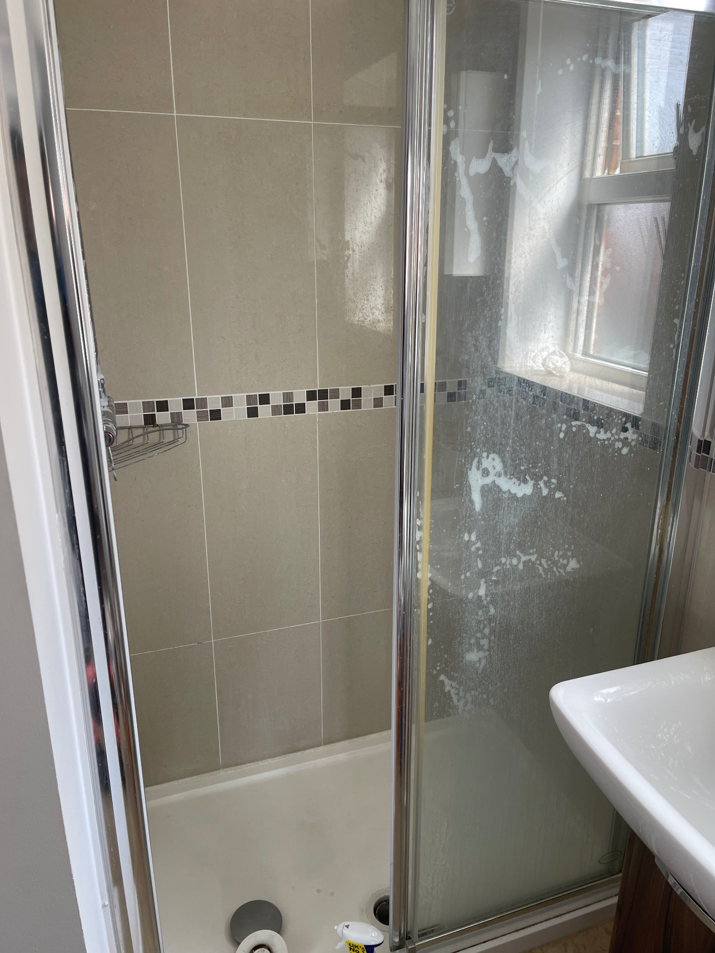 Shower enclosure glass screen, tray and tiled walls — before cleaning