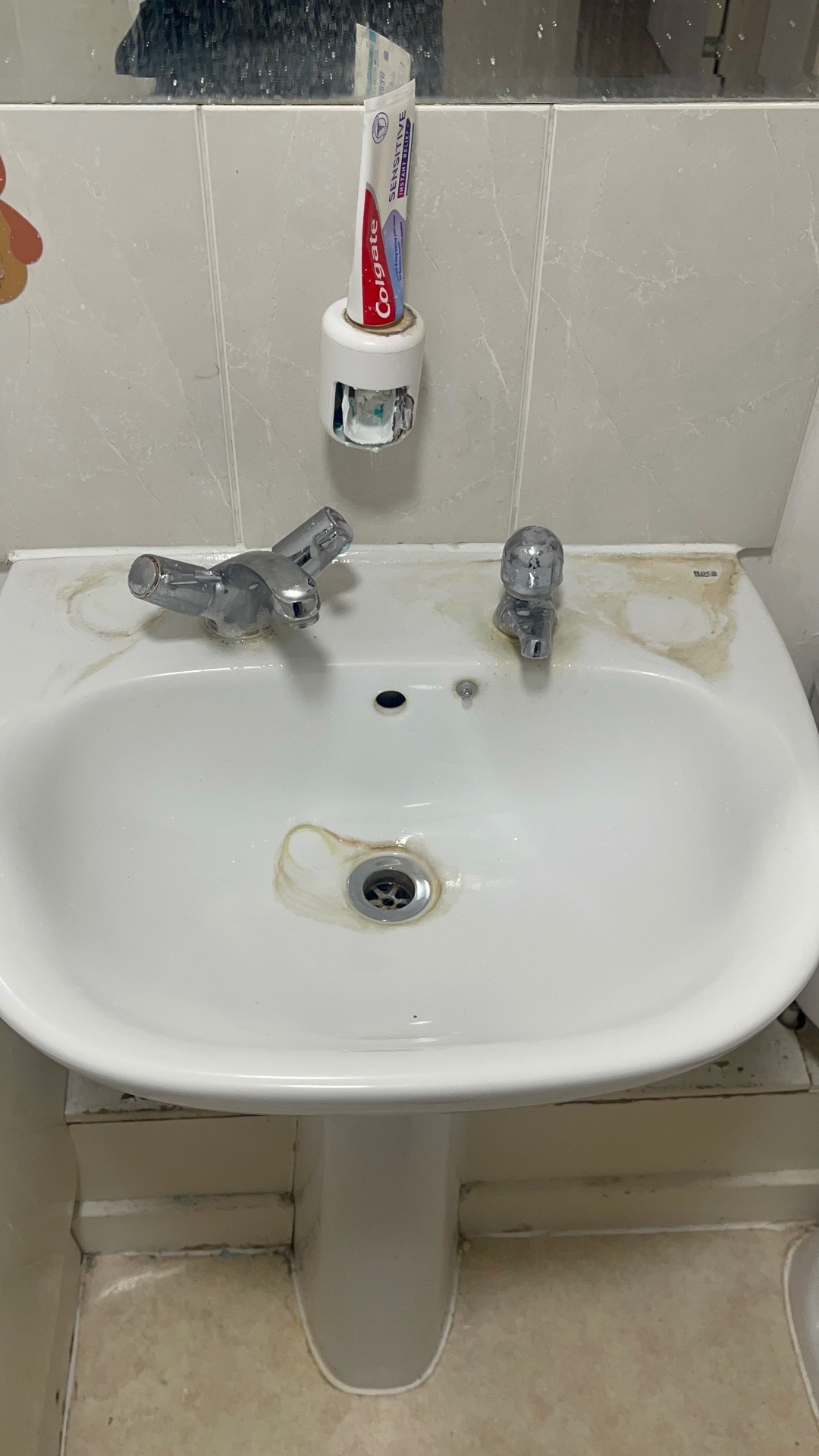 Bathroom basin, chrome taps and surrounding tiles — before cleaning